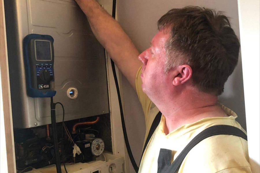 heating engineer servicing boiller